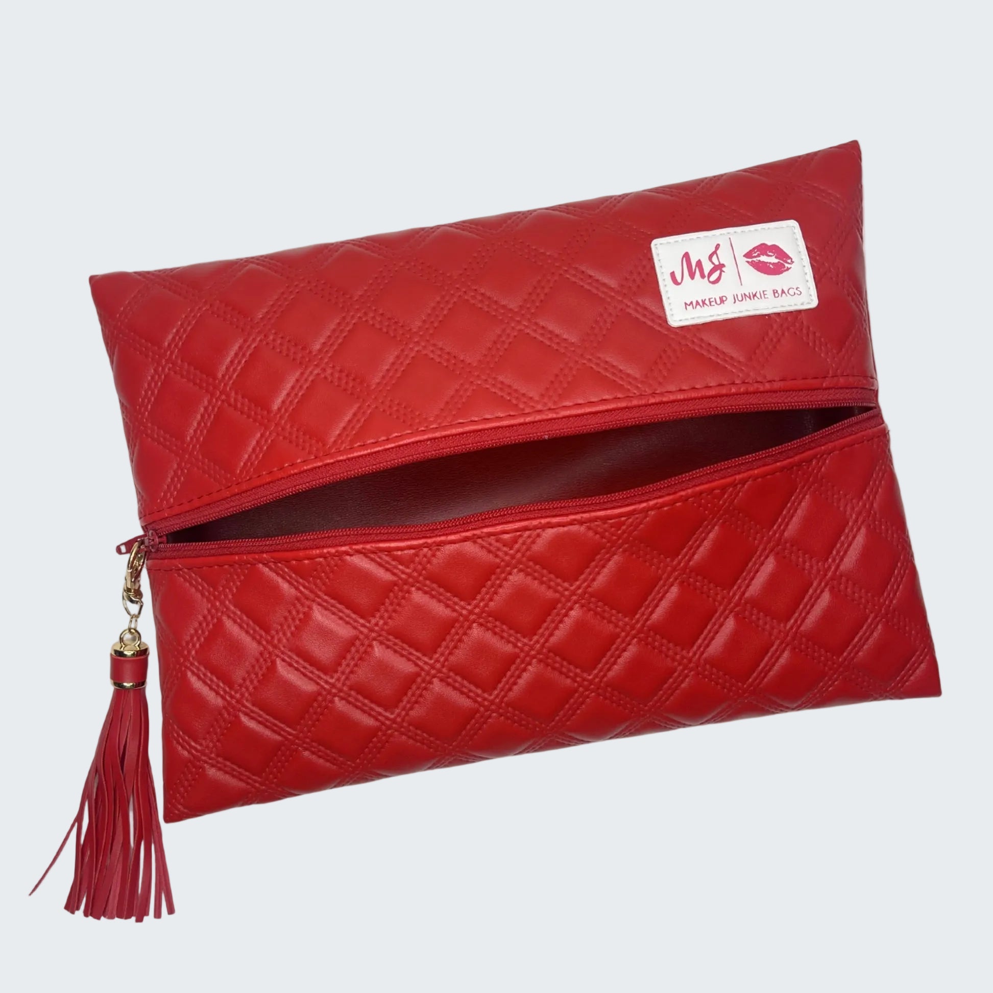 Red quilted clutch bag with a tassel on a white background