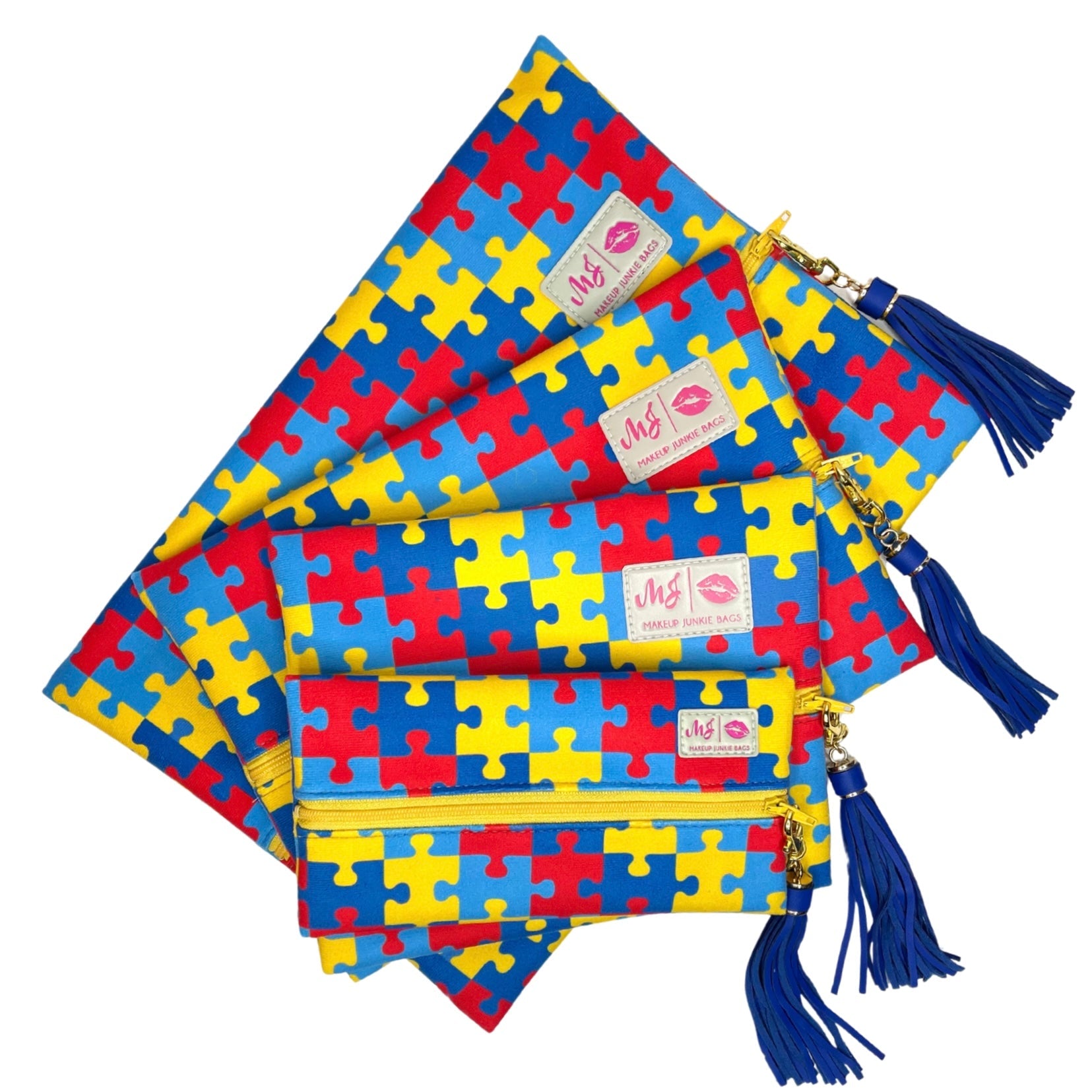 Set of colorful puzzle-patterned pouches with tassels on a white background