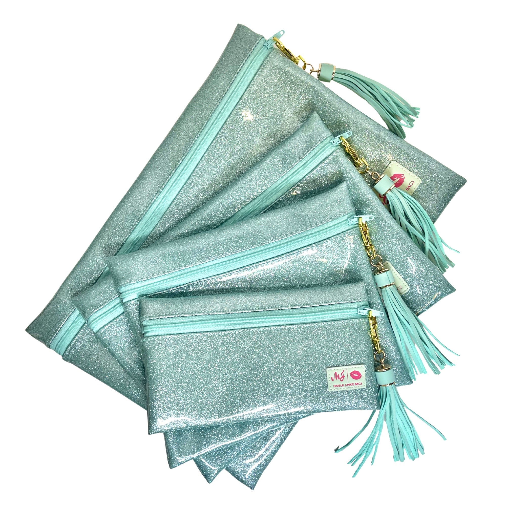 Stack of glittery teal pouches with tassels on a white background