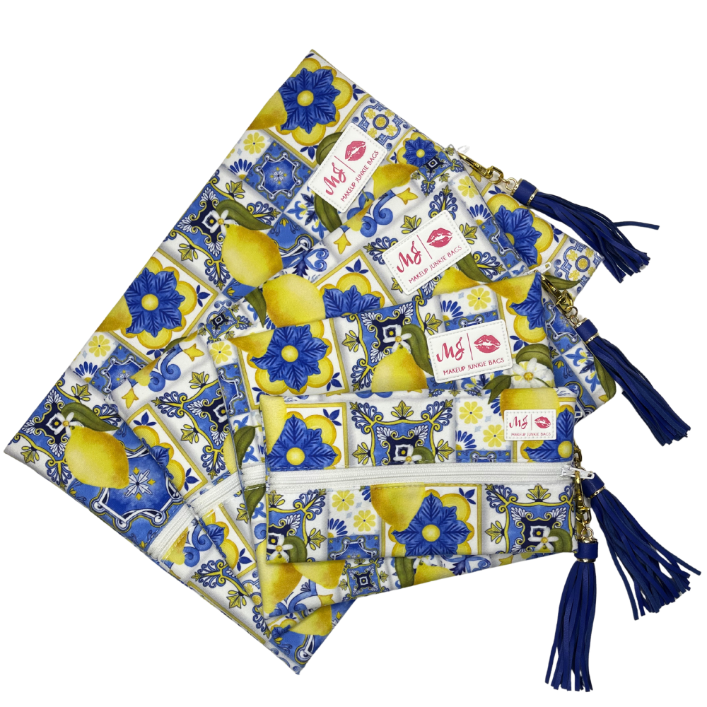 Set of three patterned bags with blue tassels on a white background
