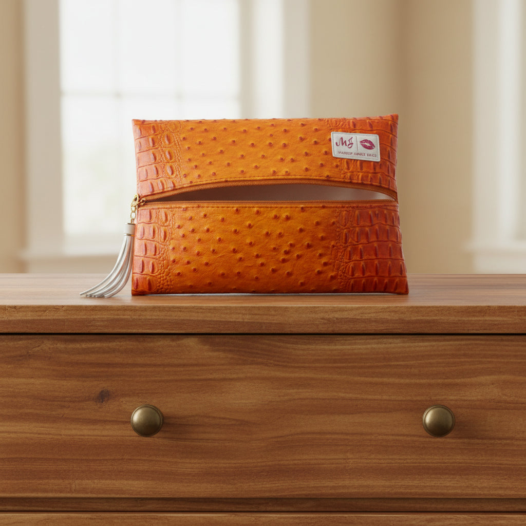 Orange textured clutch bag with a tassel on a white background