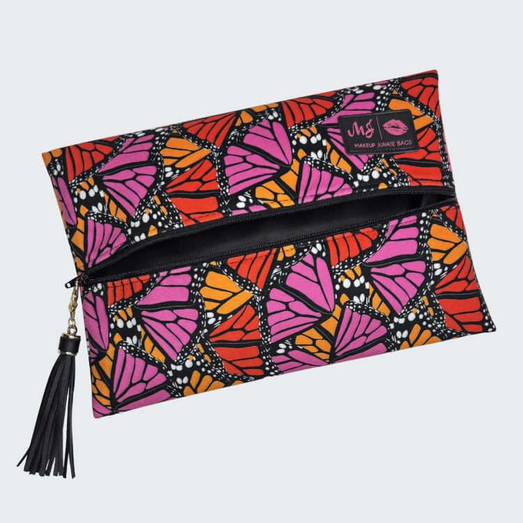 Colorful butterfly-patterned clutch bag with a tassel on a white background