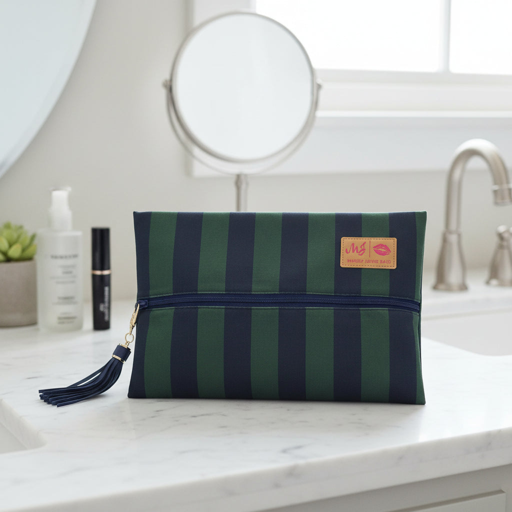 Green and navy striped pouch with a tassel on a light gray background