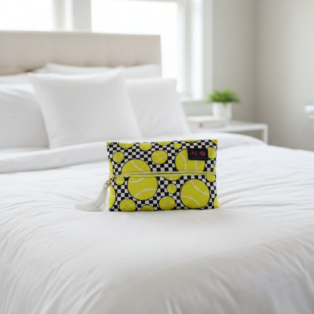Clutch bag with tennis ball pattern and checkered design on a light gray background