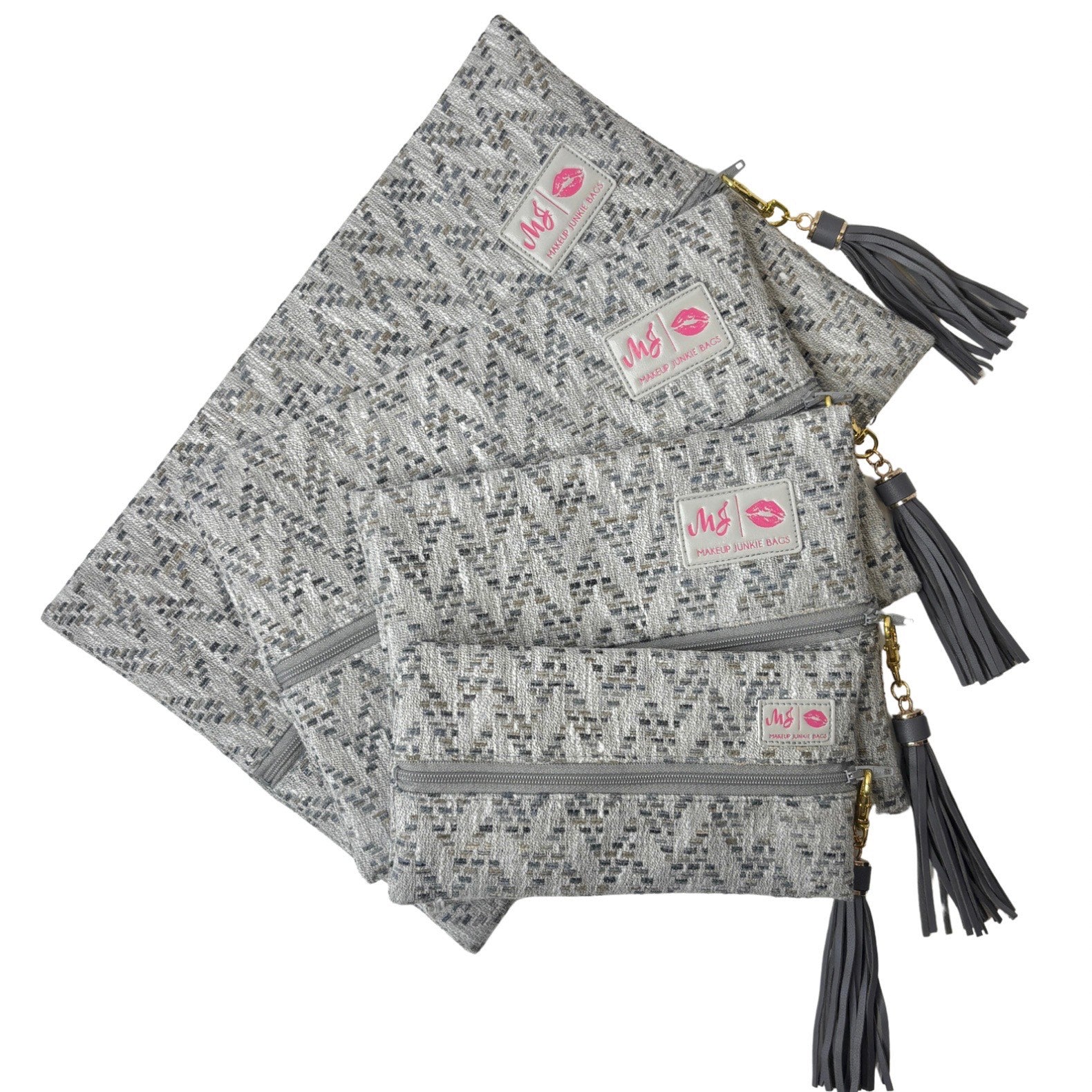 Set of three gray patterned pouches with tassels on a white background