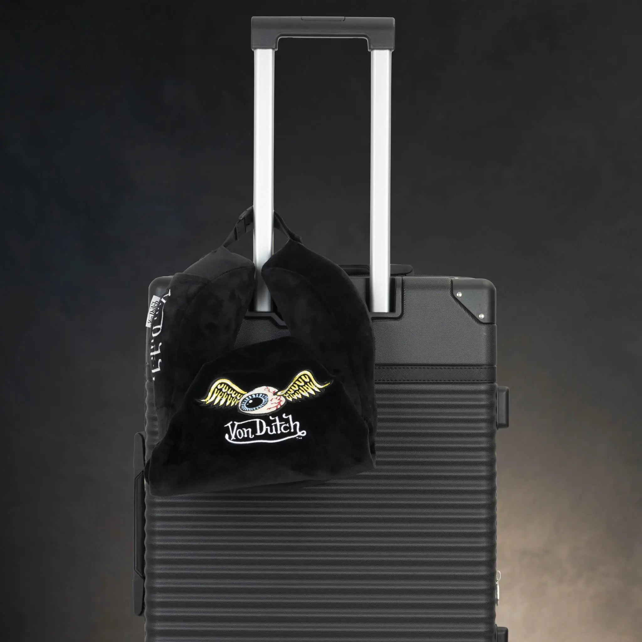 Black Von Dutch cap on a black suitcase with a dark background