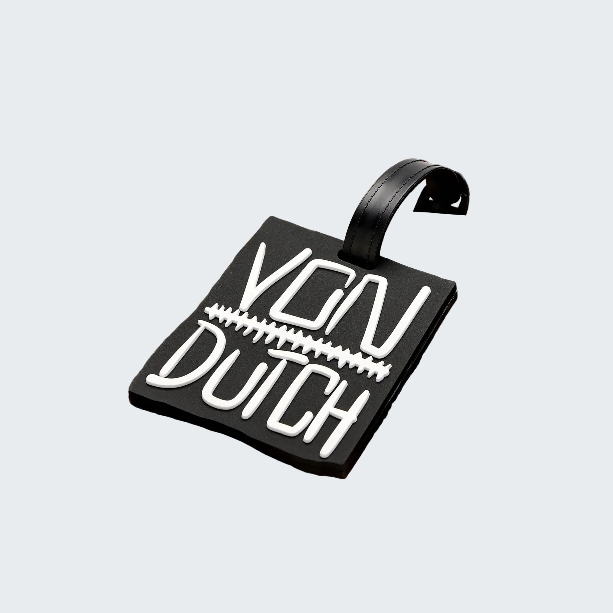 Brown suitcase with a black 'Von Dutch' luggage tag on a white background