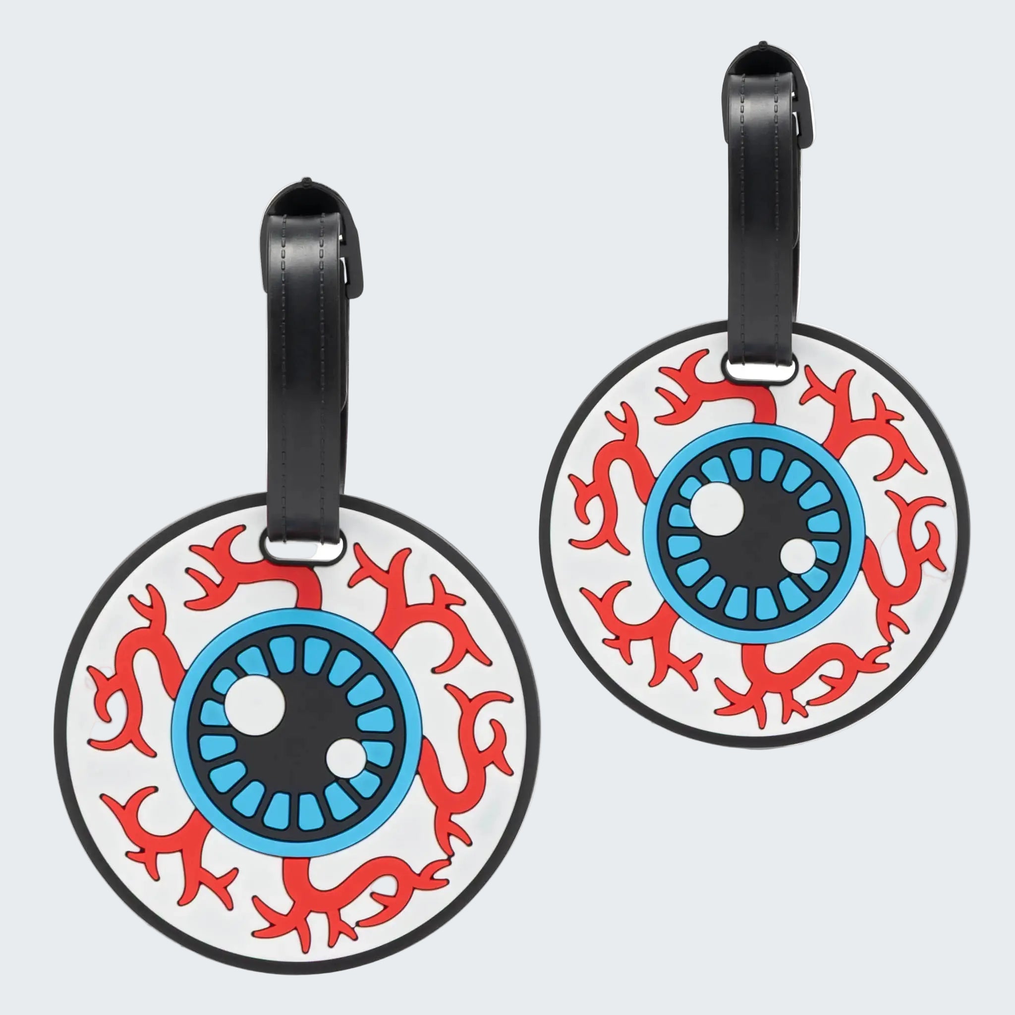 Two round luggage tags with eye design on a white background