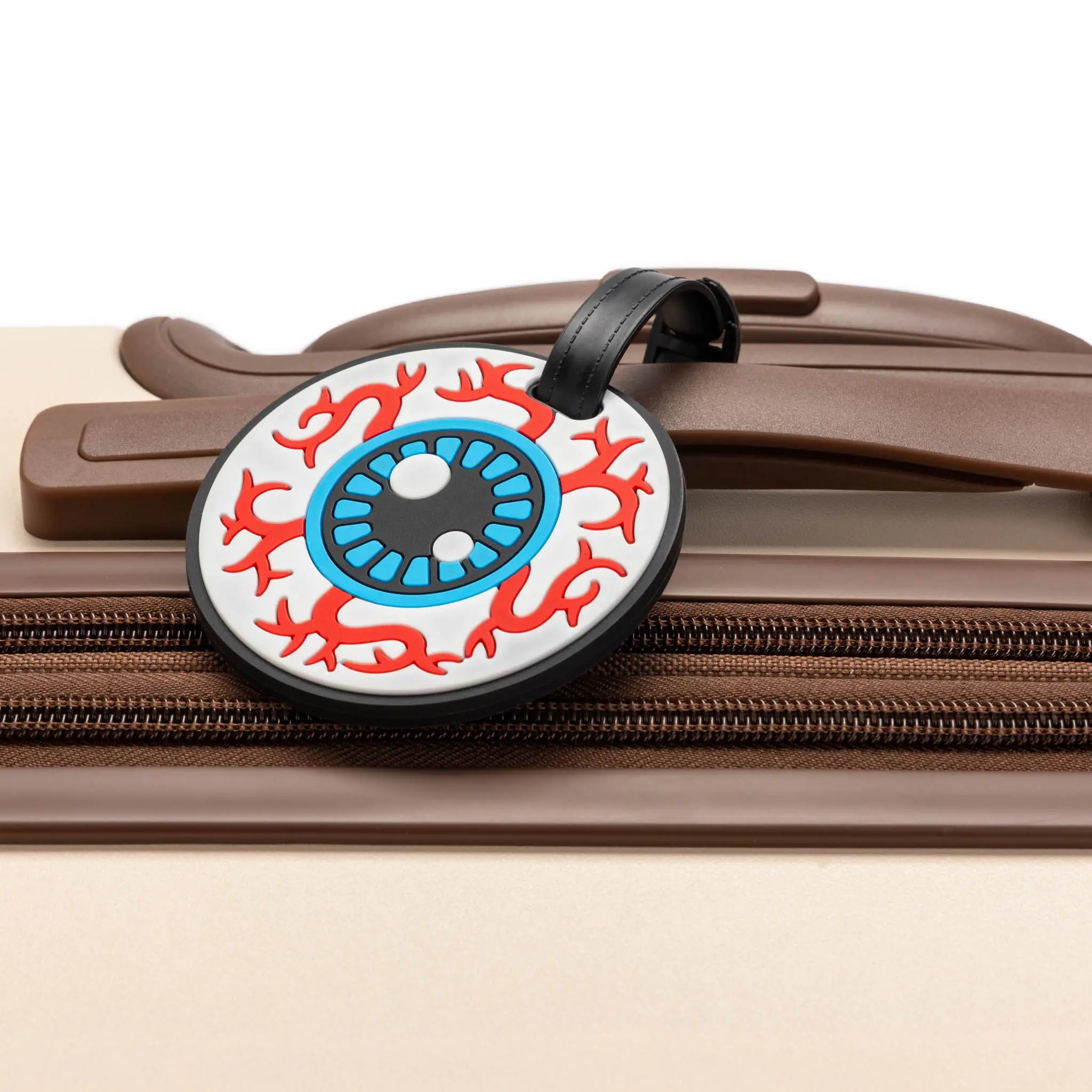 Round luggage tag with a colorful design on a suitcase