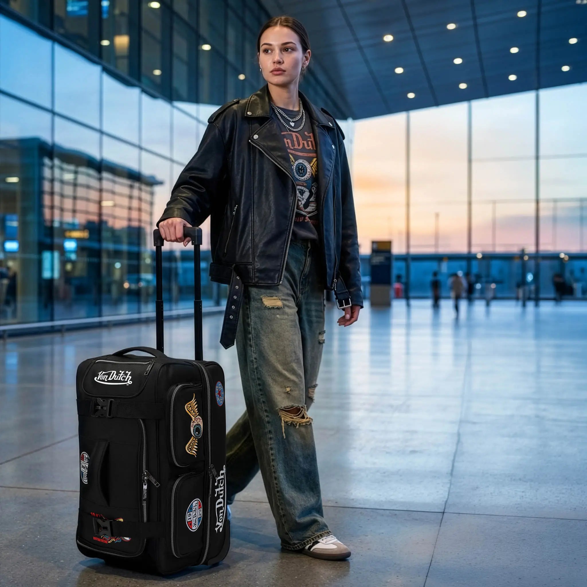 Person with a black suitcase in an airport terminal