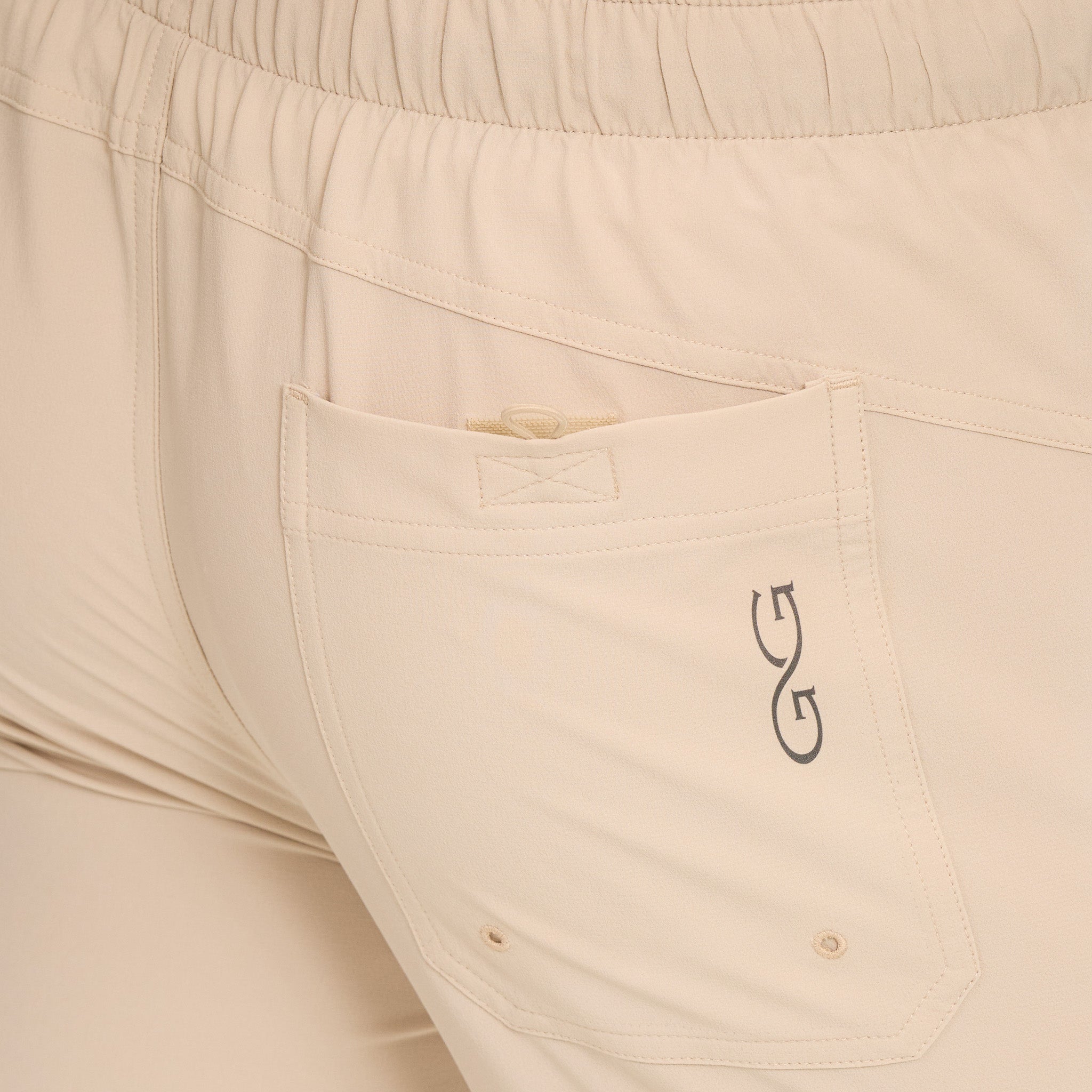 Beige pants with a logo on the pocket