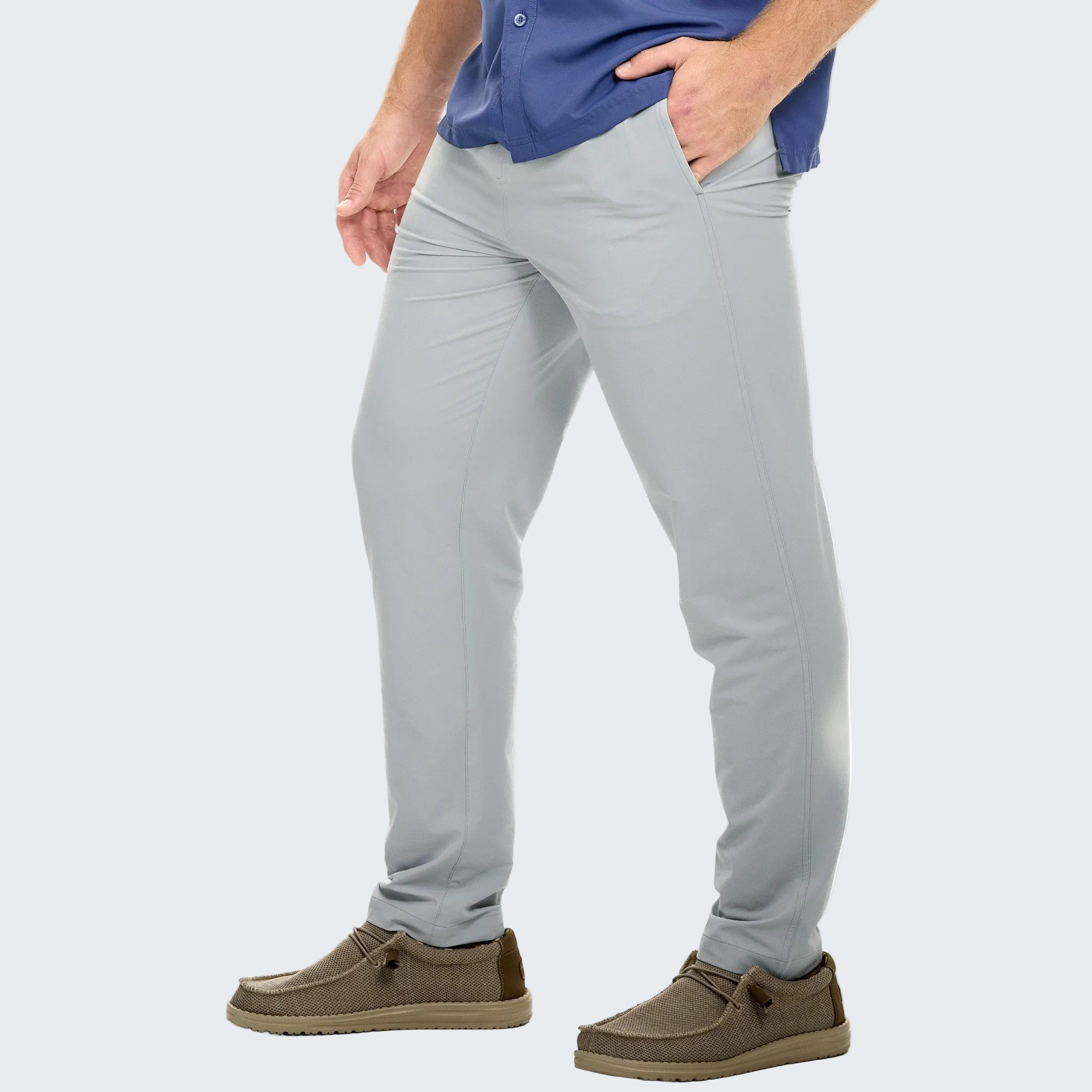 Person wearing light gray pants with a blue shirt on a white background