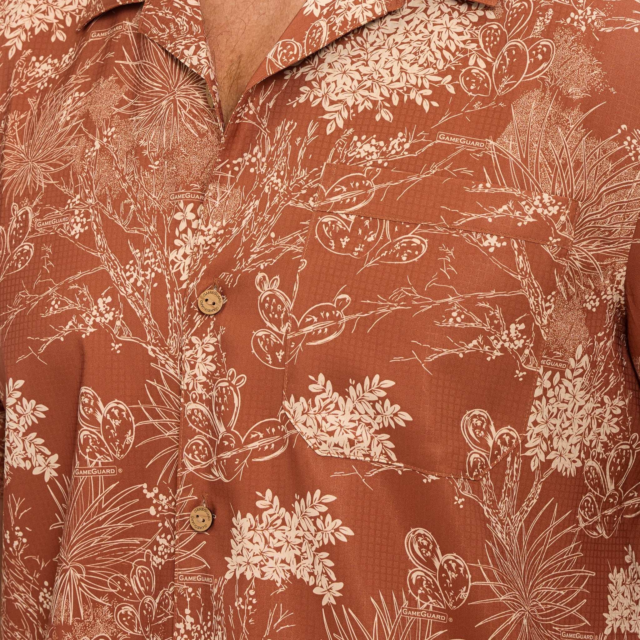 Close-up of a brown shirt with white floral and leaf pattern