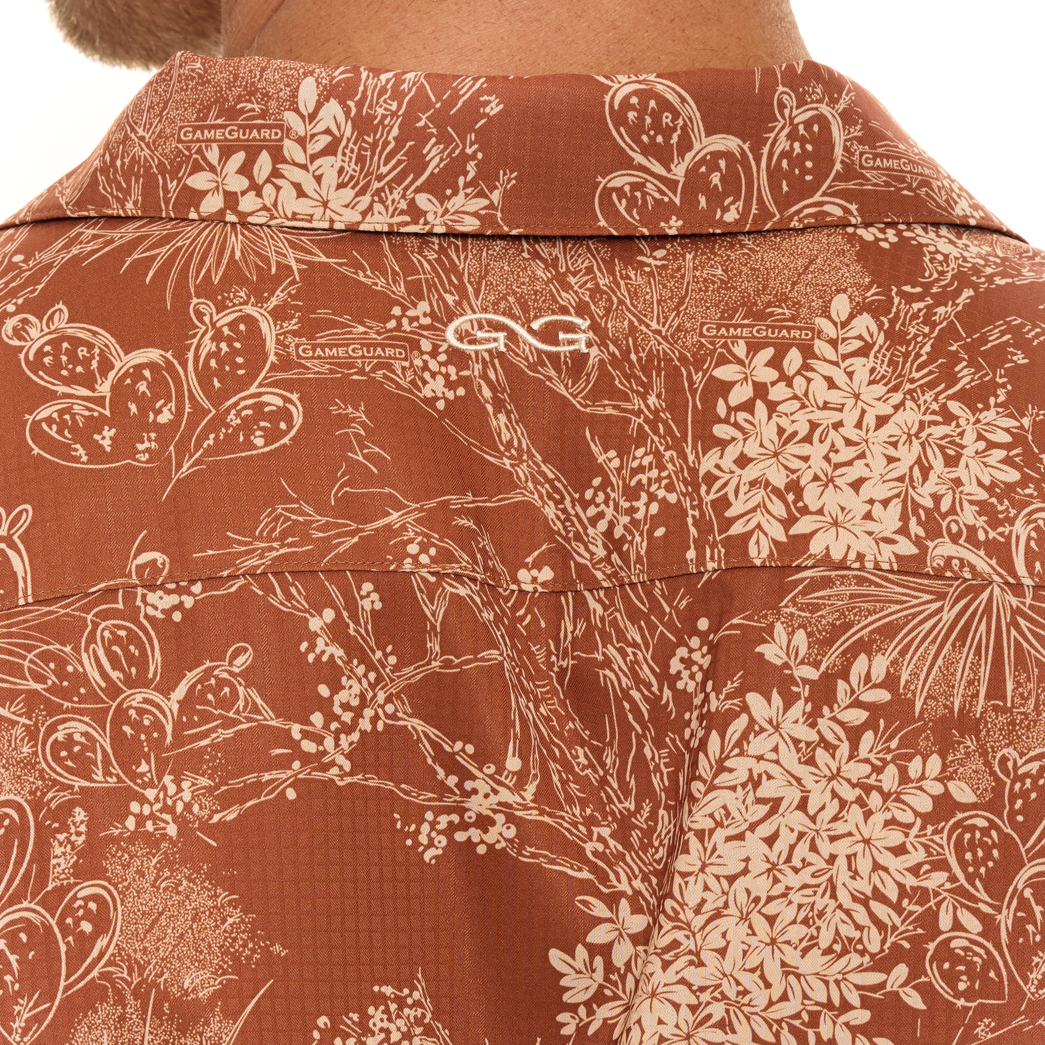 Close-up of a brown shirt with white floral pattern