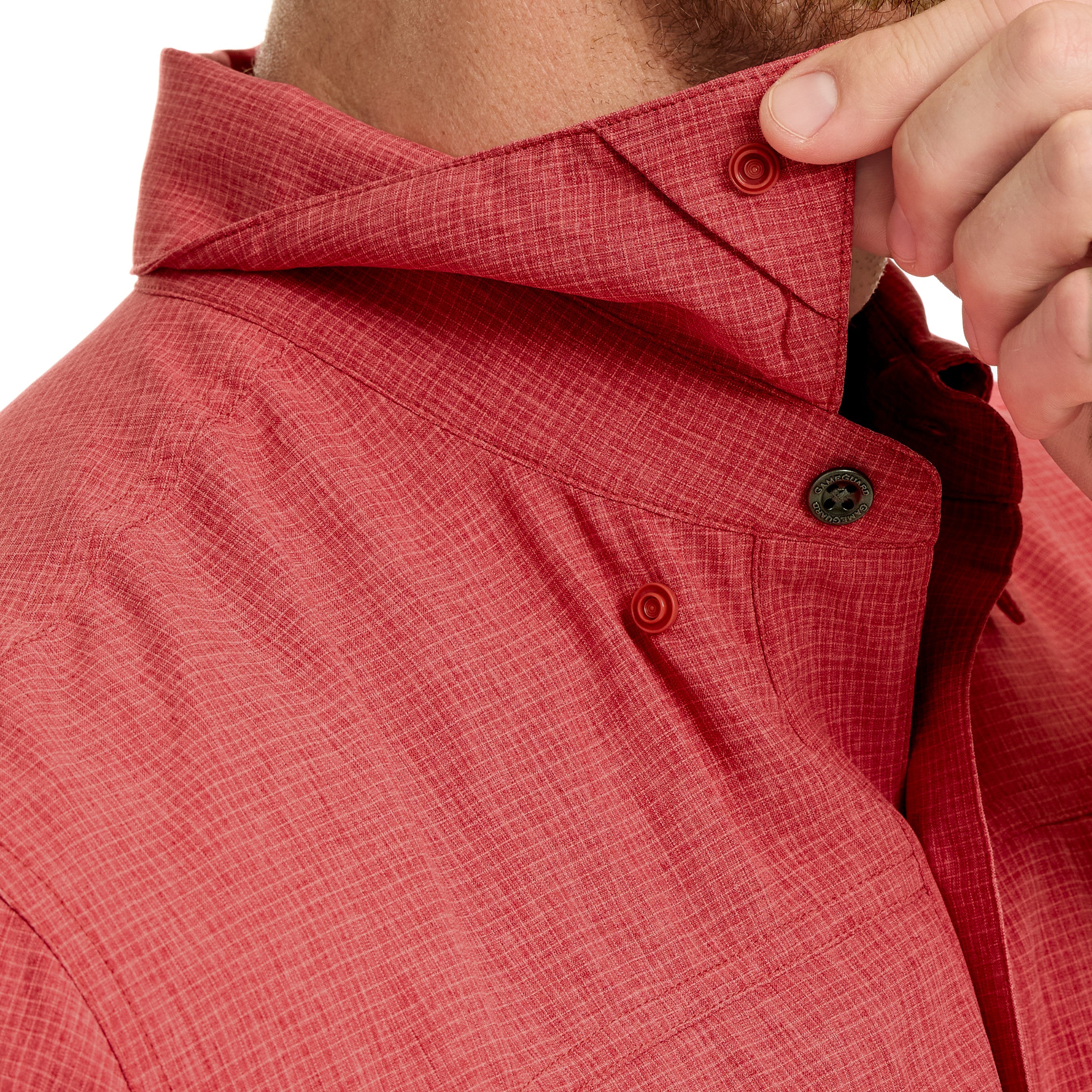 Close-up of a person adjusting the collar of a red textured shirt.
