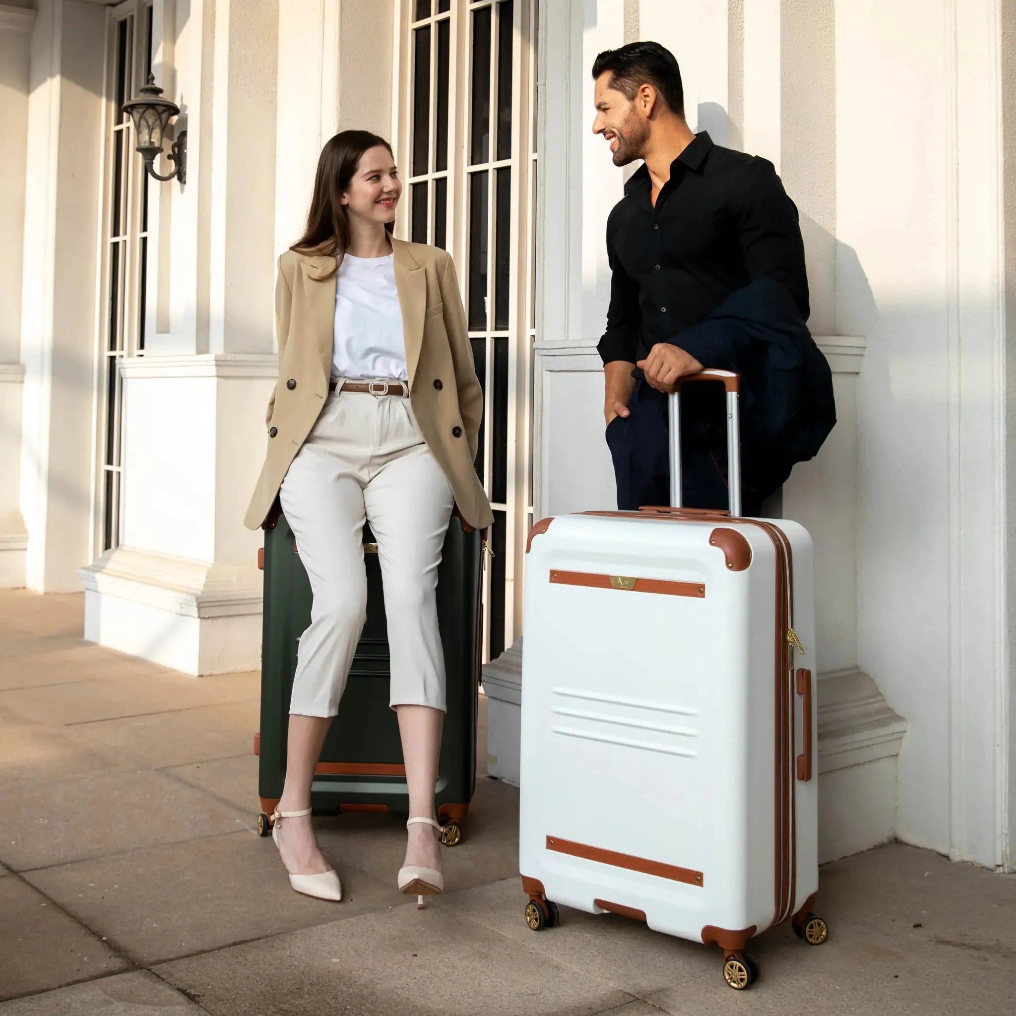 Man and woman with suitcases outside a building