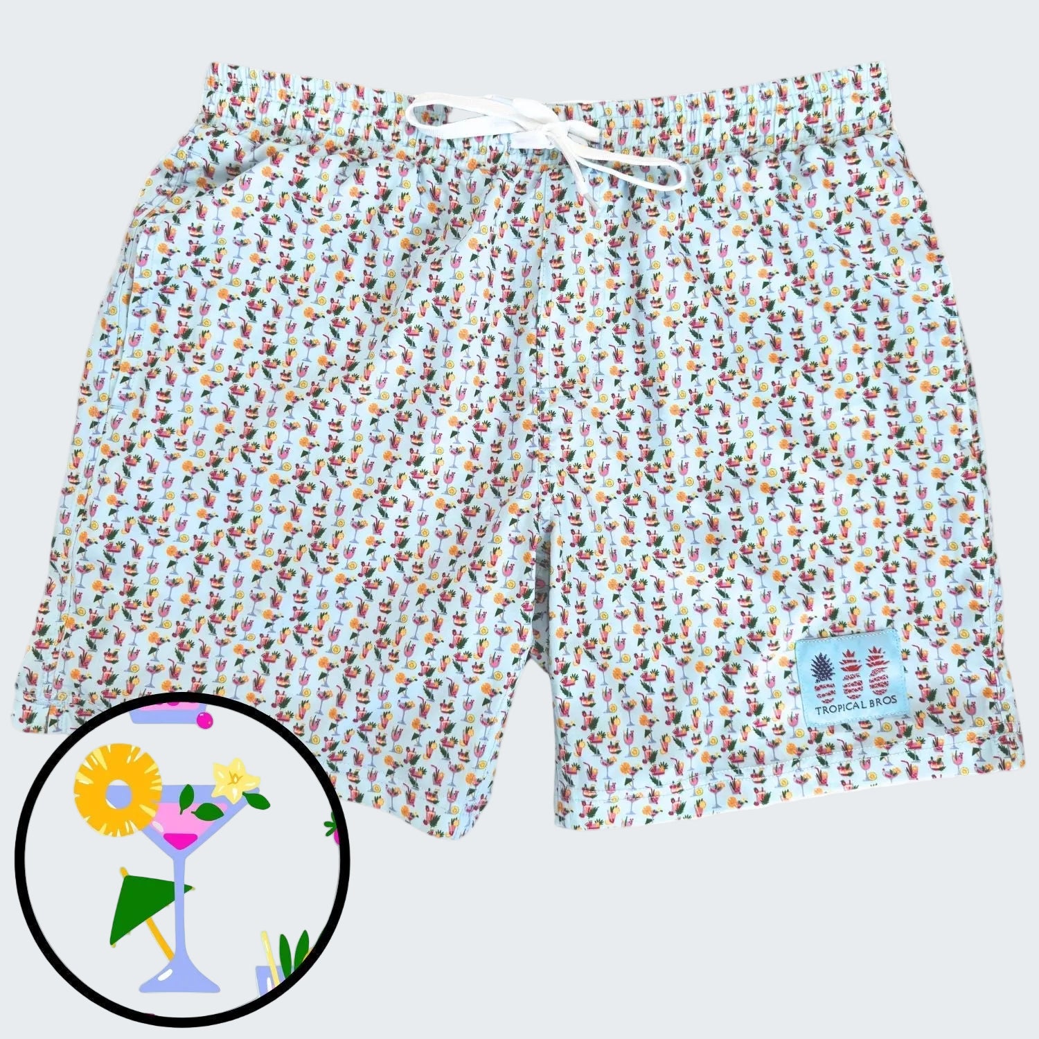 Colorful patterned shorts with a small inset of a cocktail graphic on a white background