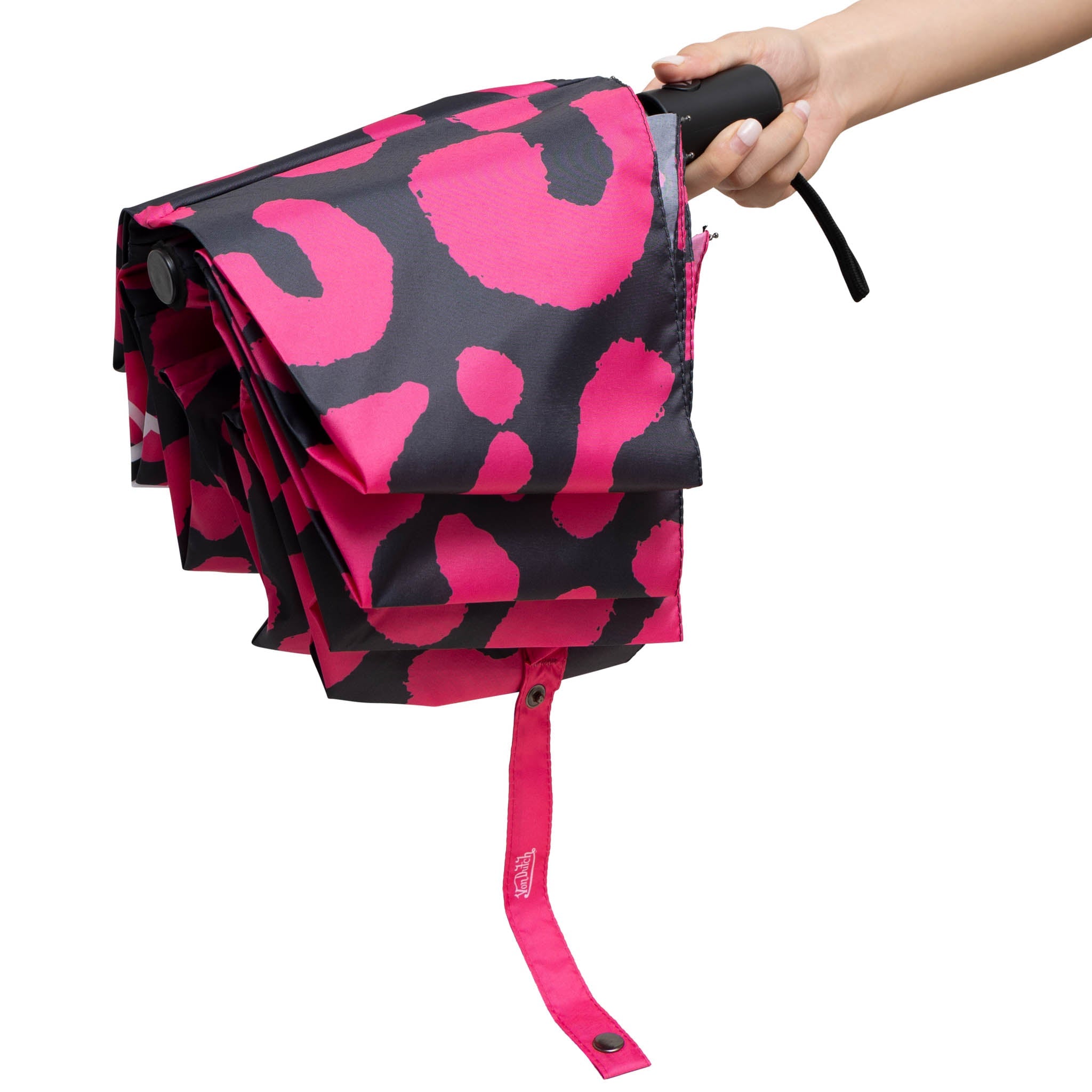 Pink and black patterned umbrella held by a hand on a white background
