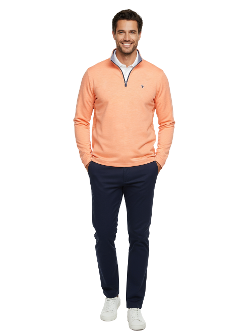 Man wearing an orange long-sleeve shirt and navy pants on a white background