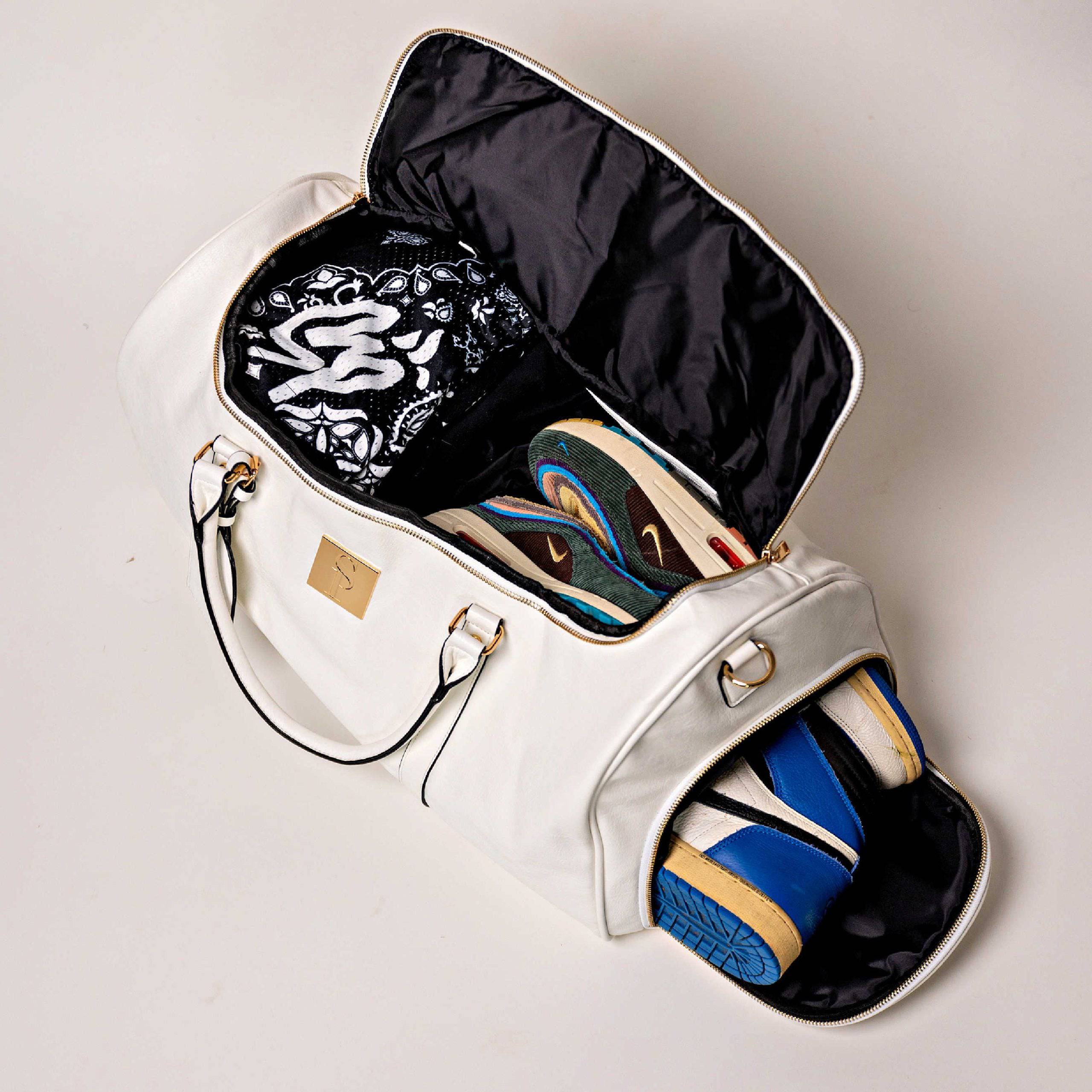 White handbag with open compartments displaying various shoes on a light gray background