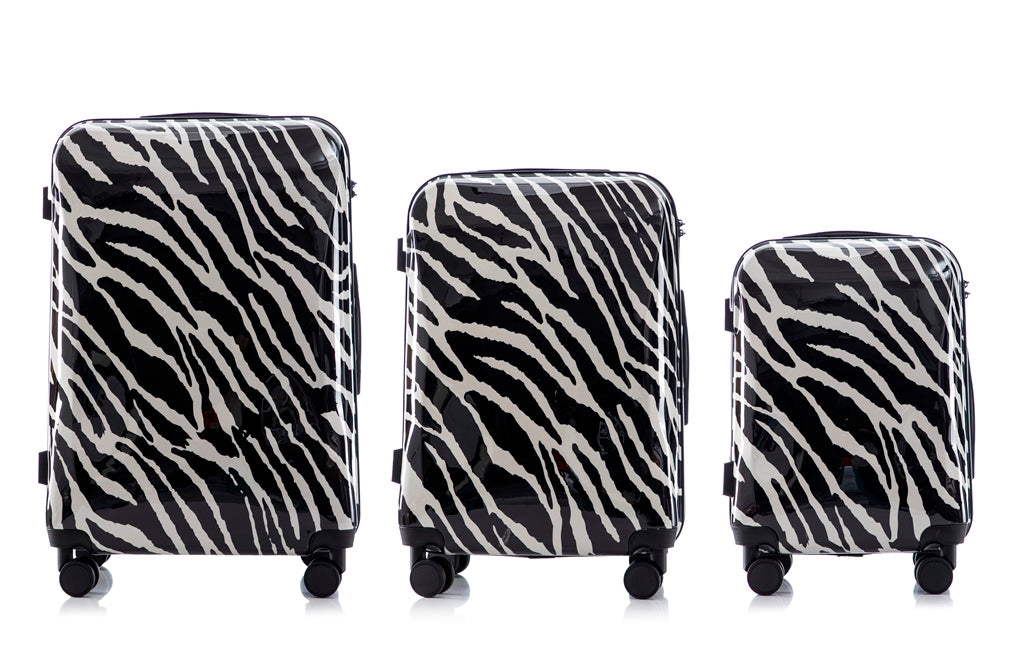 Three zebra-patterned suitcases of different sizes on a white background