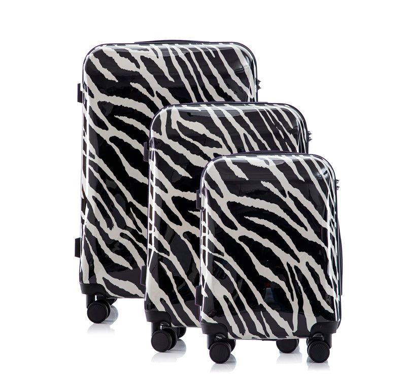 Three zebra-patterned suitcases of different sizes on a white background