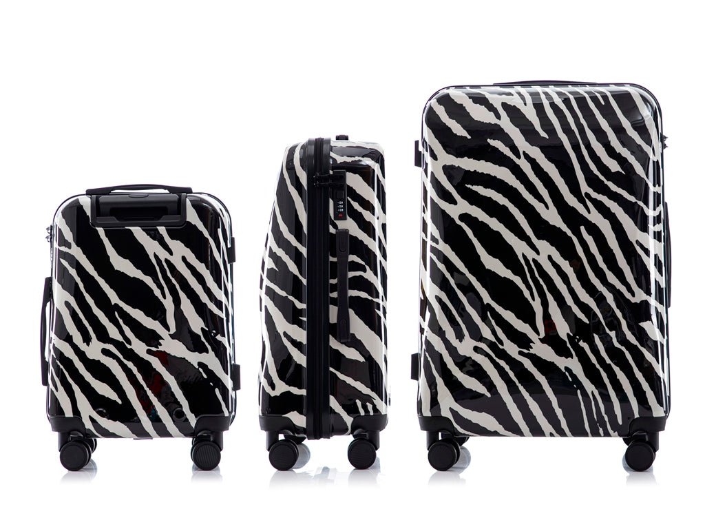 Set of three zebra-patterned suitcases of different sizes on a white background