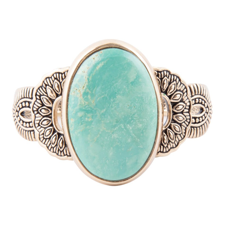 Turquoise stone ring with ornate bronze band on a white background