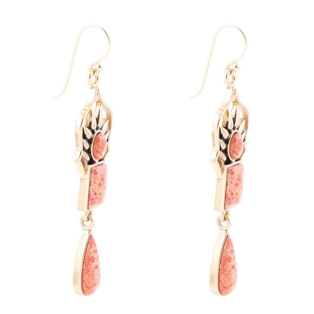 Gold earrings with pink stone drops on a white background