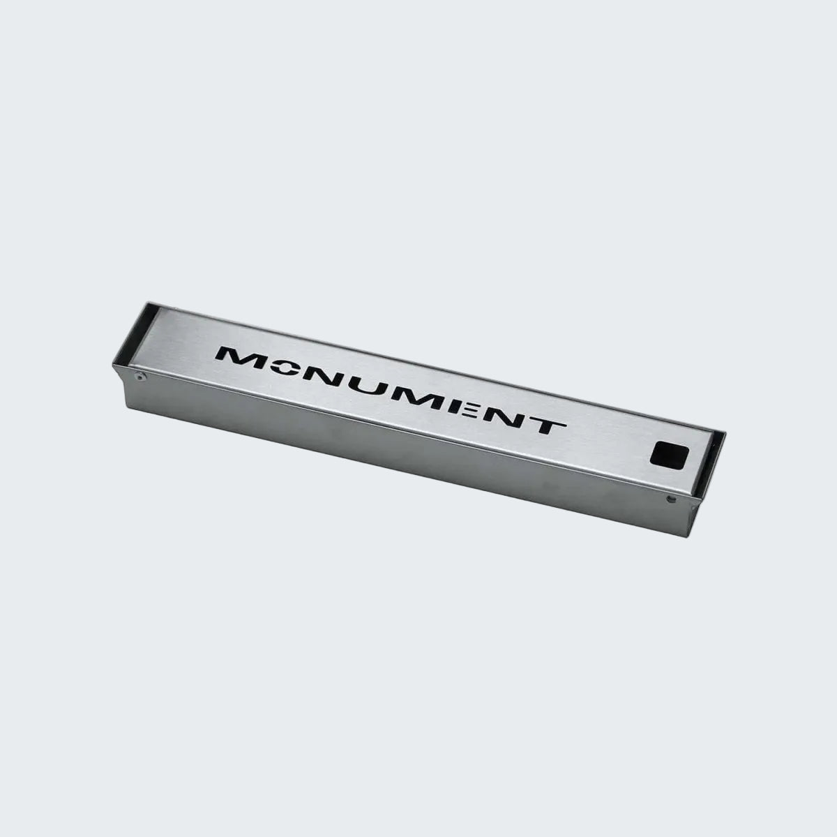 Metallic rectangular object with 'MONUMENT' branding on a white background