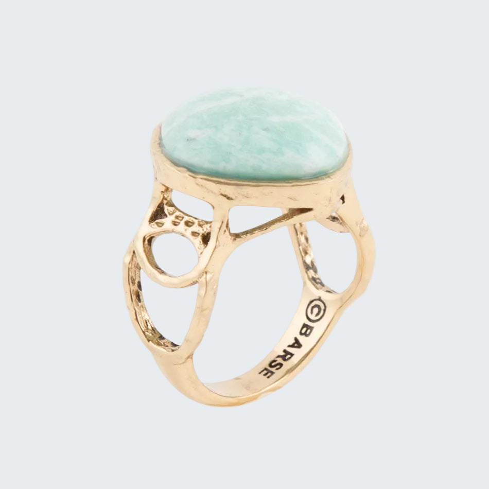 Gold ring with a green stone on a white background