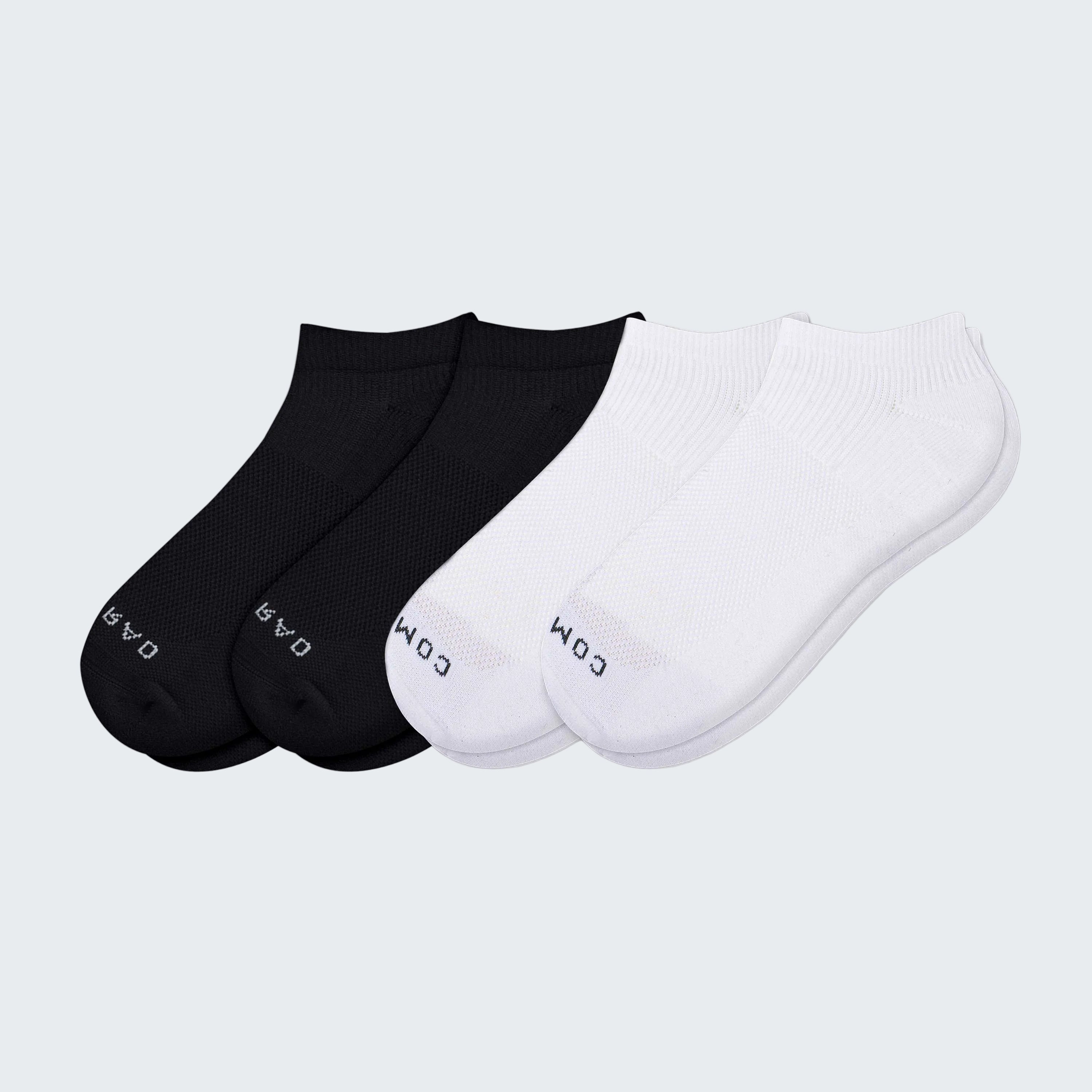Two pairs of black and white ankle socks on a white background