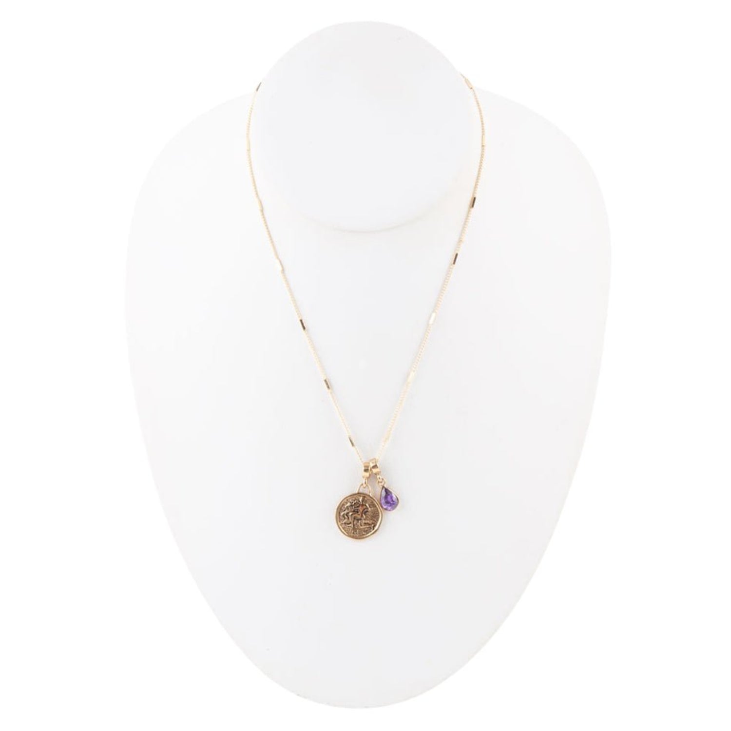Gold necklace with a pendant on a white stand
