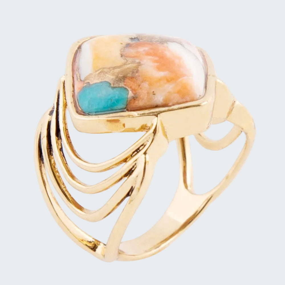Gold ring with a colorful stone and turquoise accent on a white background