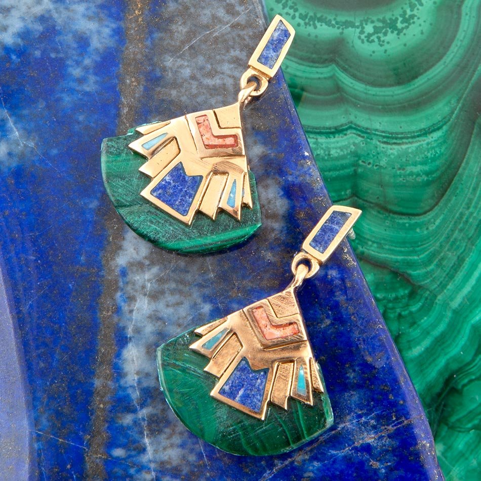 Gold and gemstone earrings on a blue and green stone background