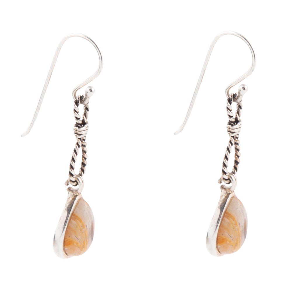Pair of silver earrings with teardrop-shaped orange stones on a white background