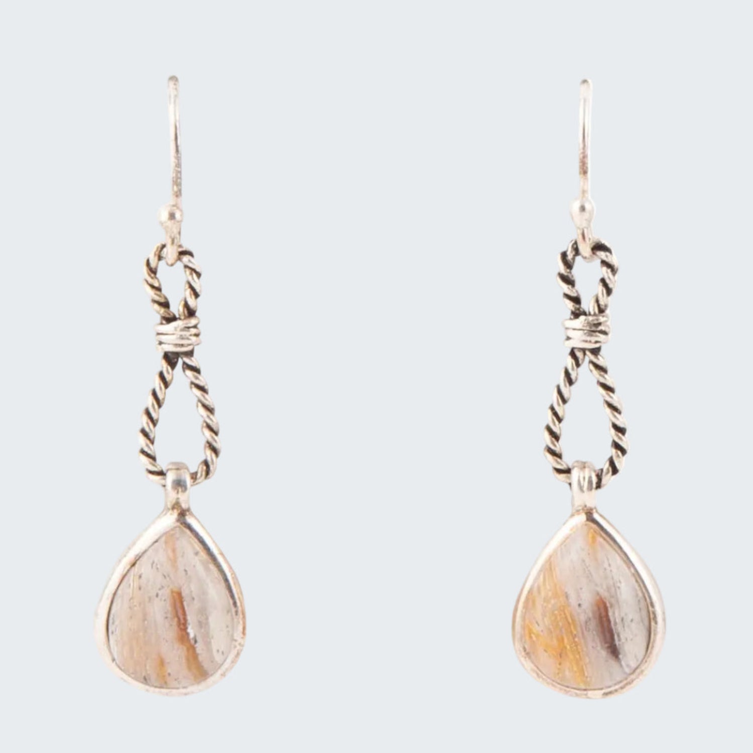 Pair of earrings with teardrop-shaped stones and braided wire designs on a white background