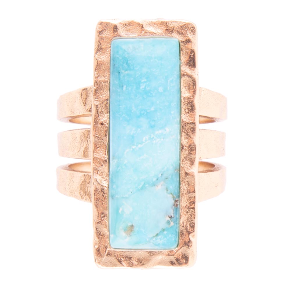 Ring with turquoise stone and rose gold band on white background
