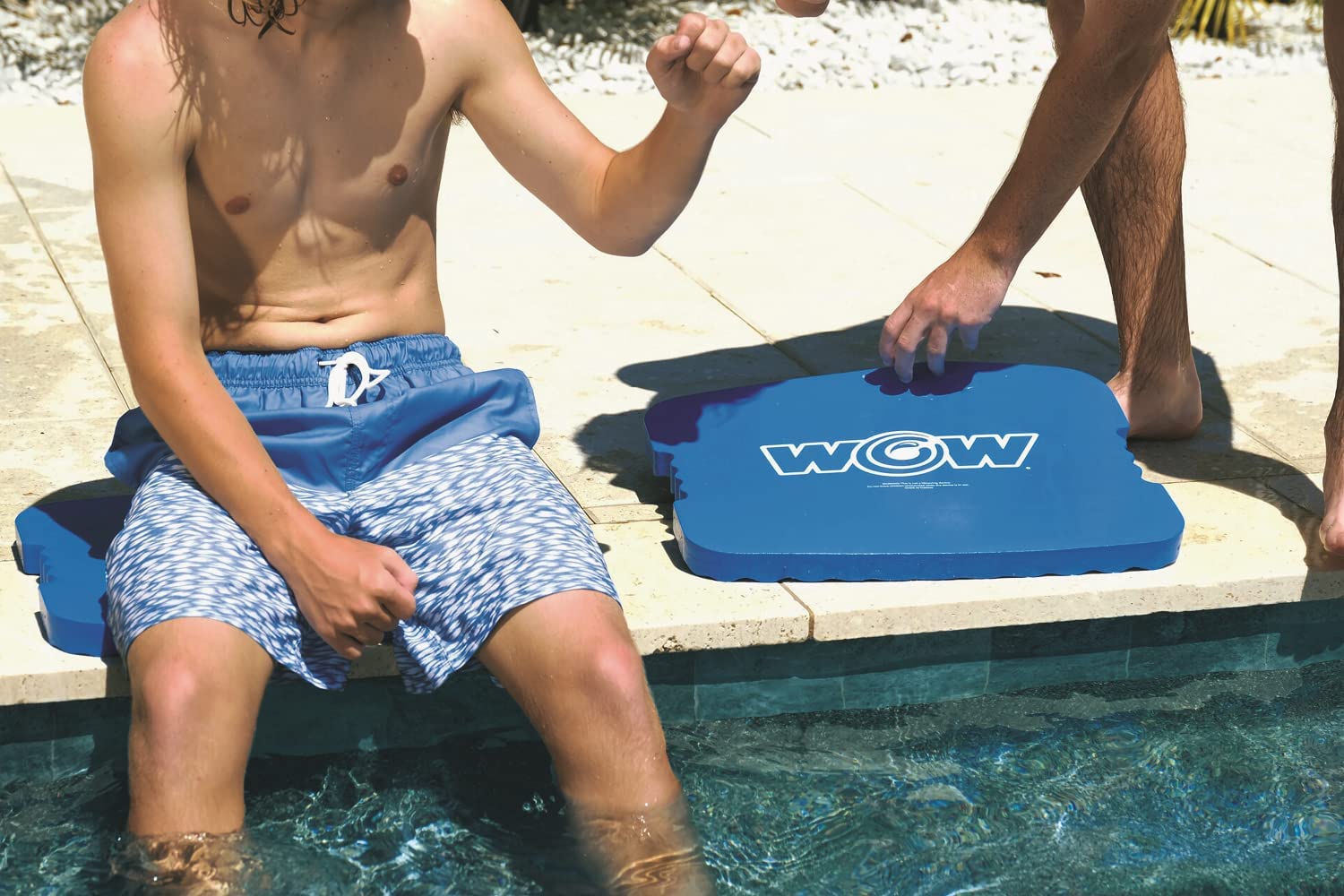 Person using a blue pool浮板 with 'WOW' branding by a pool.