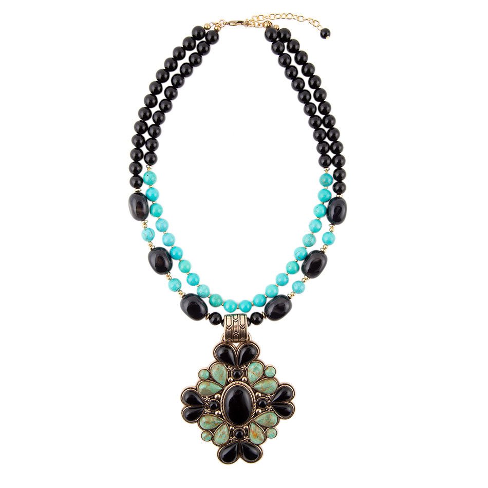 Necklace with black and turquoise beads and a decorative pendant on a white background
