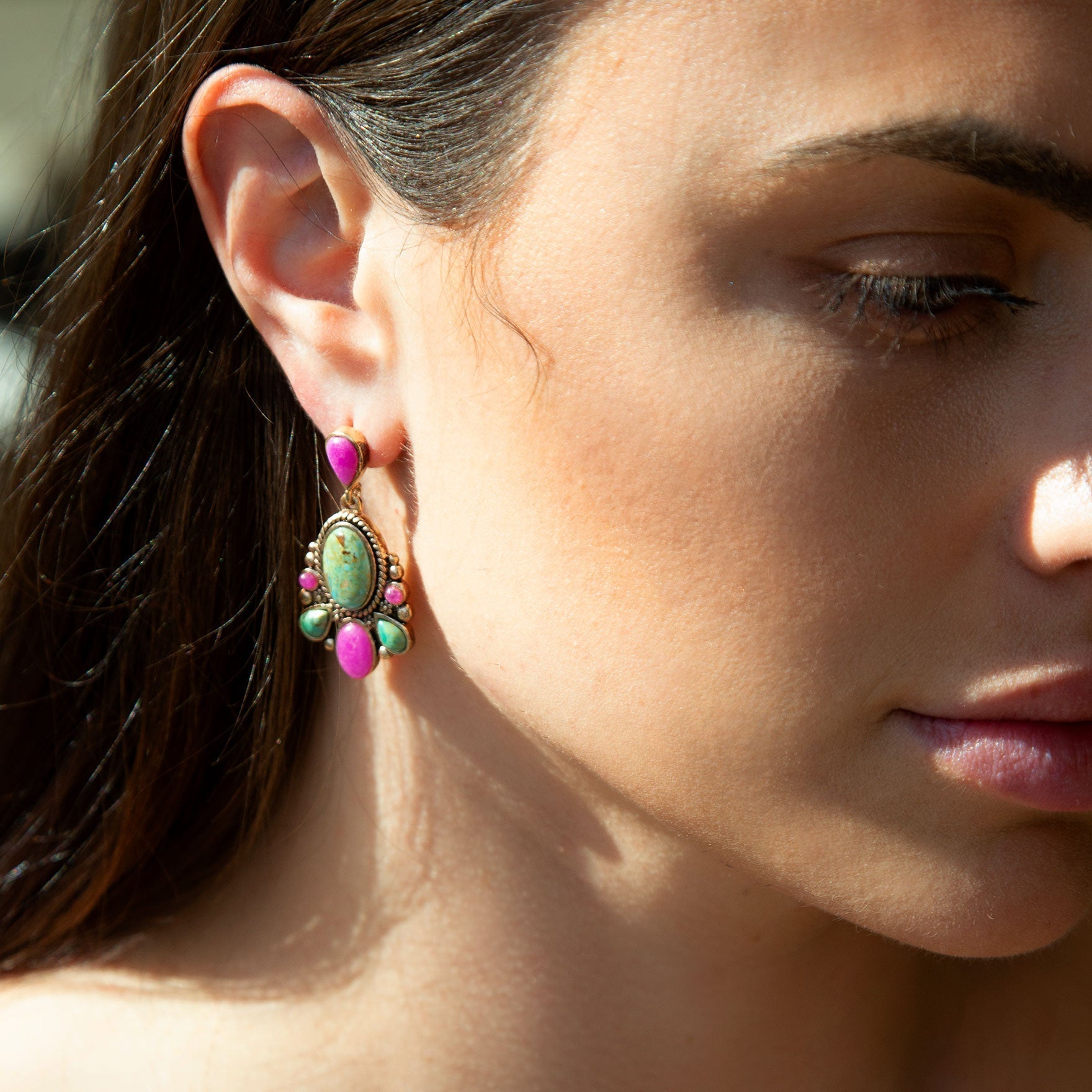 Close-up of a woman wearing colorful earrings with a blurred background
