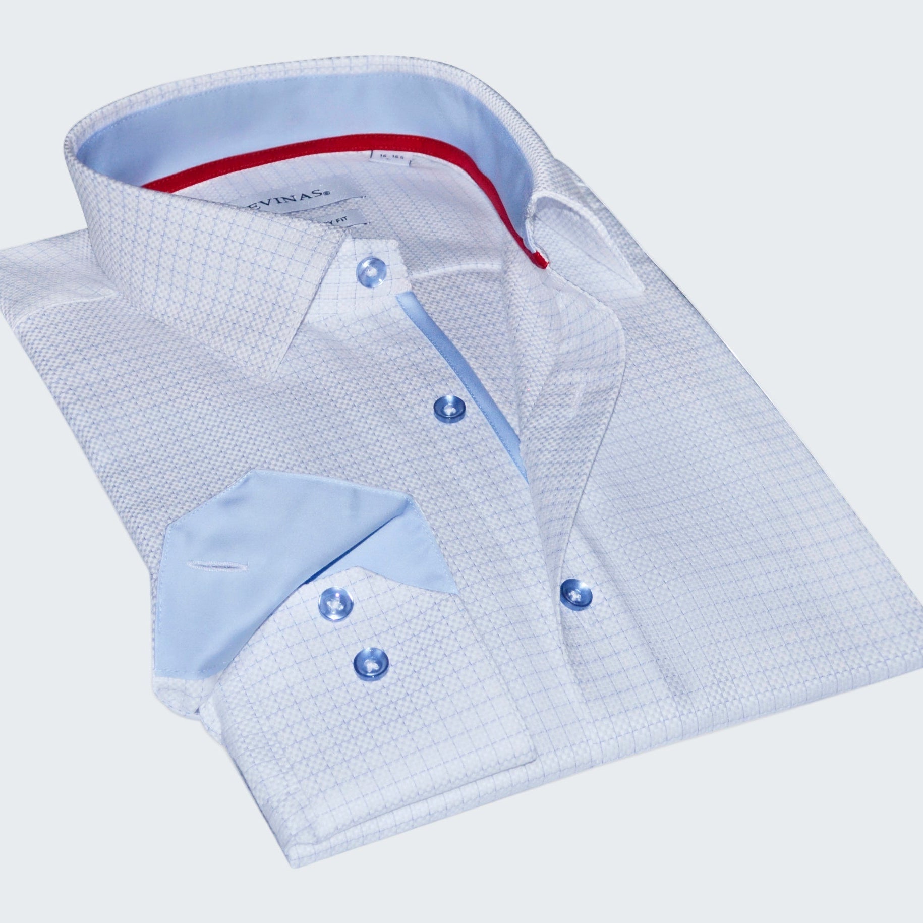 Folded light blue checkered shirt with red lining on a white background