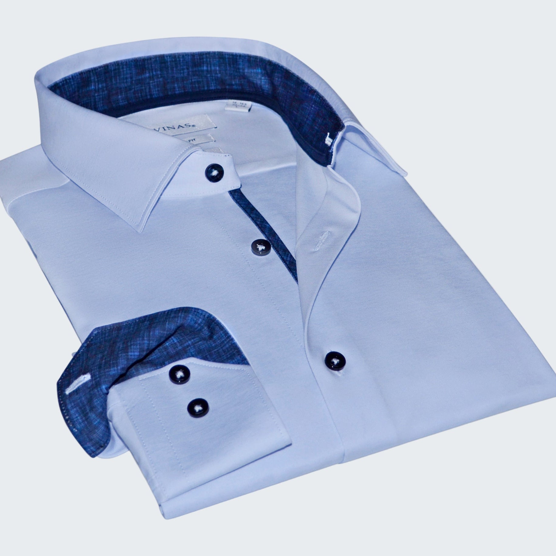 Folded light blue dress shirt with dark blue interior on a white background