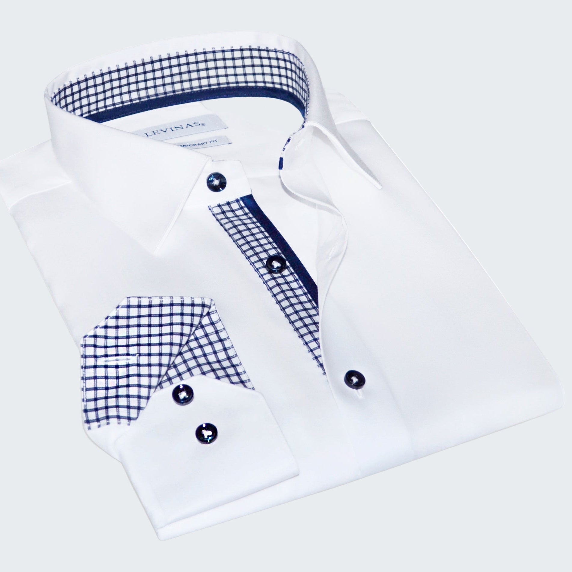 Folded white dress shirt with blue plaid accents on a white background