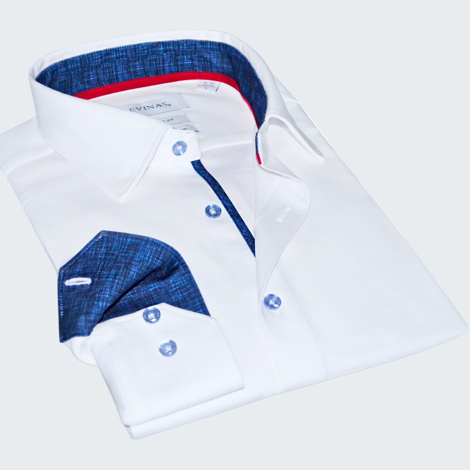 Folded white shirt with blue and red interior details on a white background