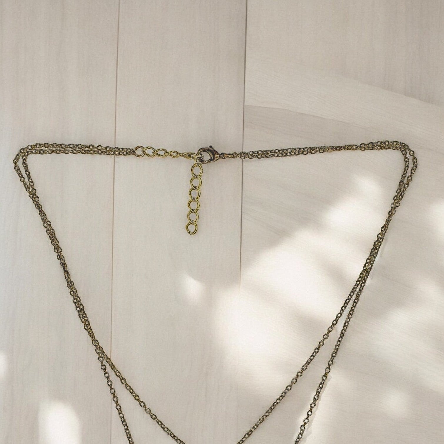 Gold chain necklace on a light wooden surface