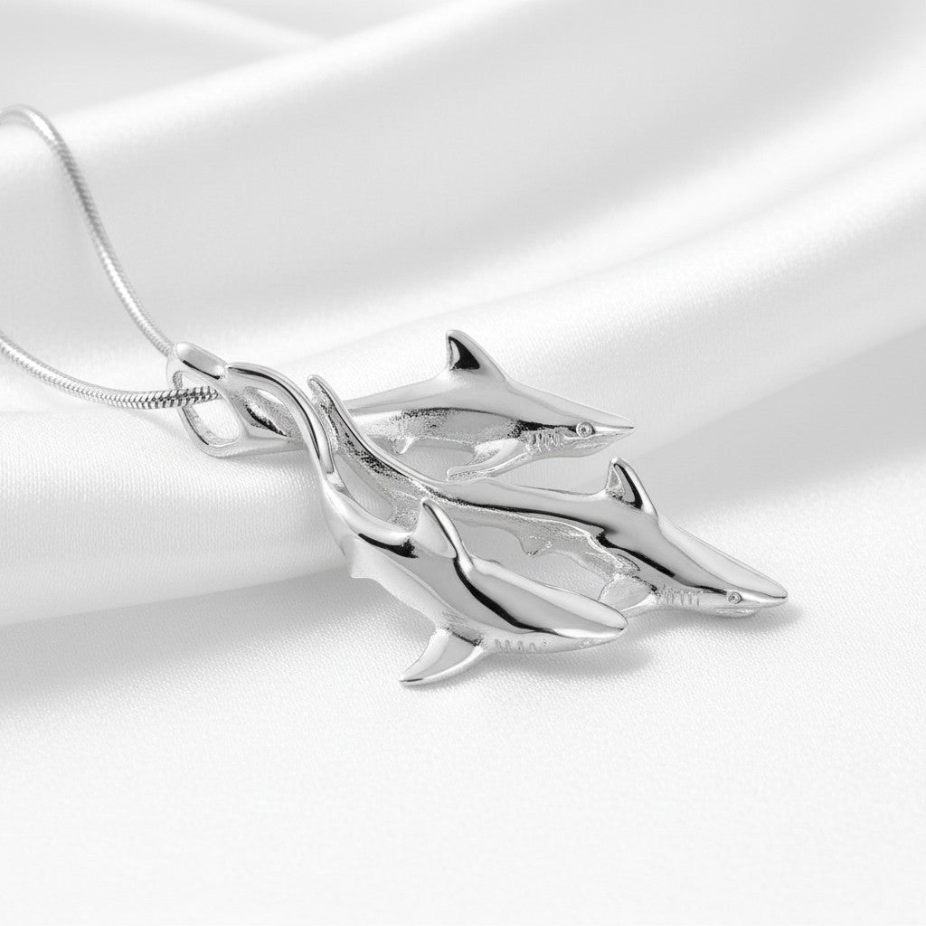 Silver dolphin pendant on a white satin background