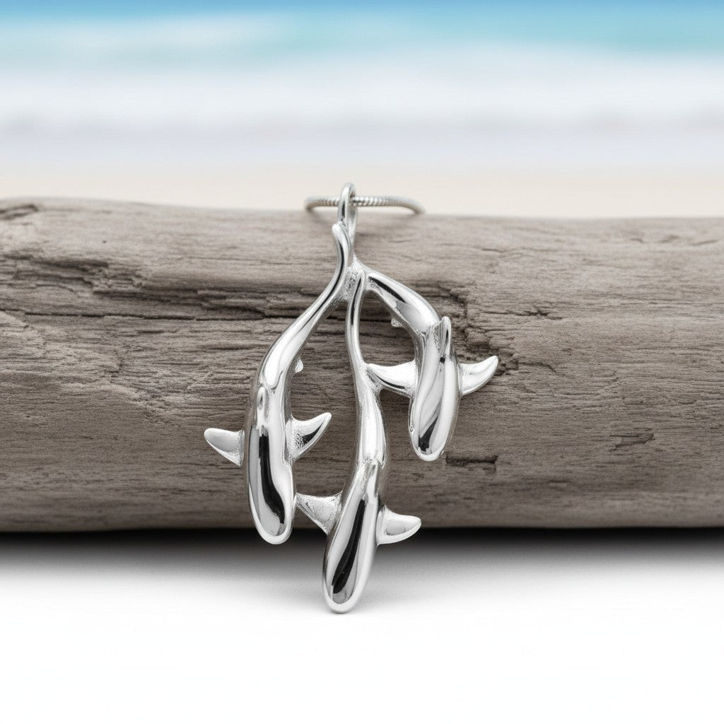 Silver earrings on a piece of driftwood with a blurred natural background