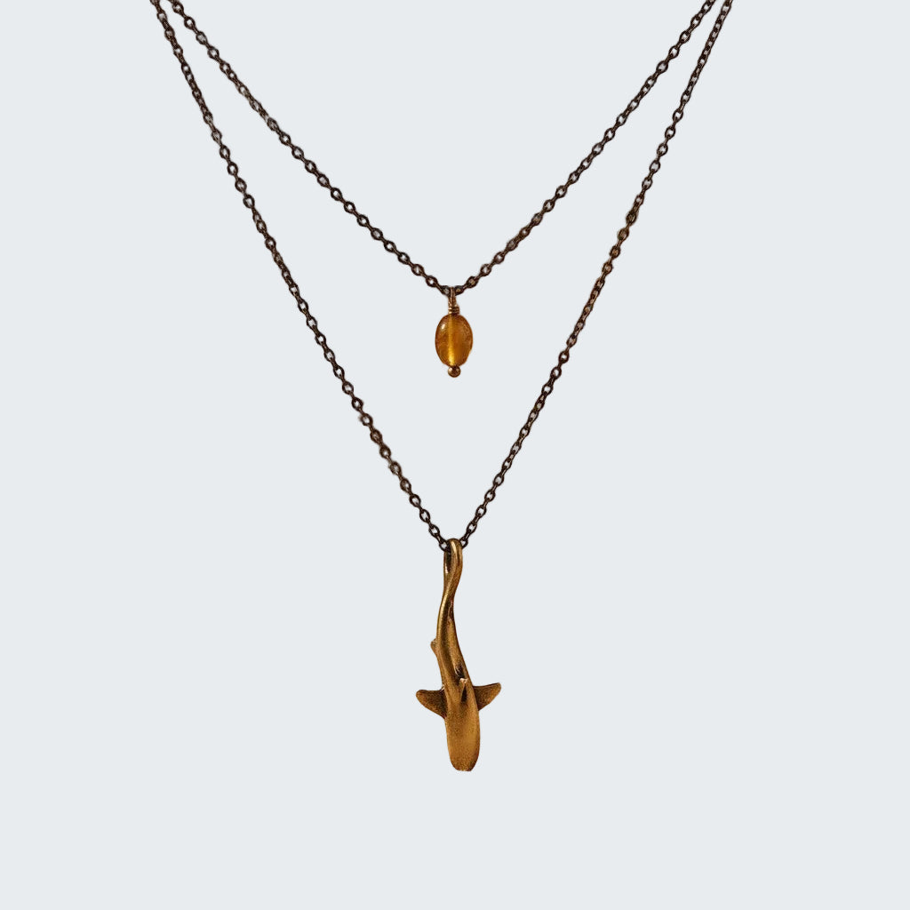 Two necklaces with pendants on a beige fabric background