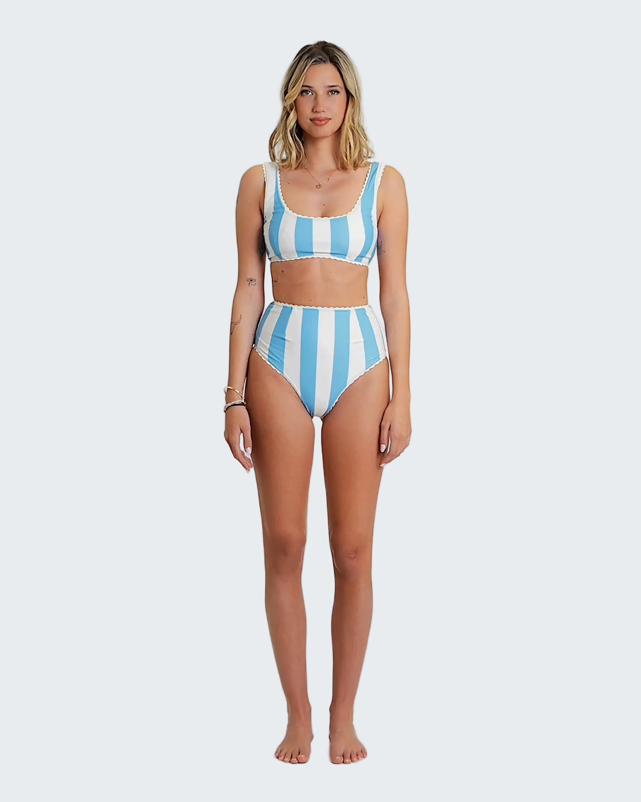 Woman wearing a blue and white striped bikini set on a white background